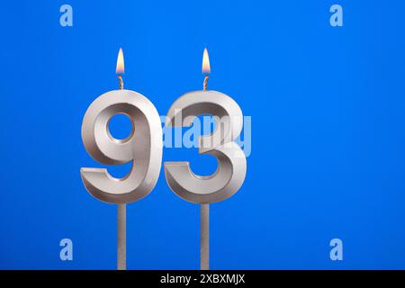 Candela di compleanno numero 93 - biglietto di auguri su sfondo blu Foto Stock