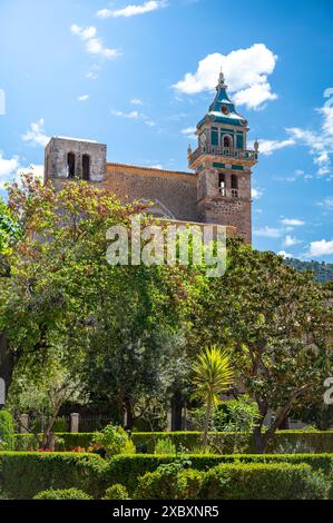 Iglesia de la Cartuja Church Tower, Valldemossa, Maiorca, durante la giornata di sole con alberi davanti, tiro verticale, Maiorca Foto Stock