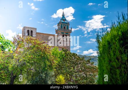 Iglesia de la Cartuja Church Tower, Valldemossa, Maiorca, durante la giornata di sole con alberi davanti, foto orizzontale, Maiorca Foto Stock