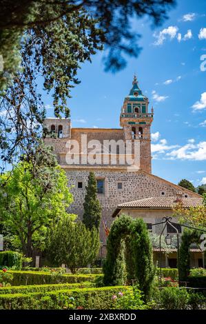 Iglesia de la Cartuja Church Tower, Valldemossa, Maiorca, durante la giornata di sole con alberi davanti, tiro verticale, Maiorca Foto Stock