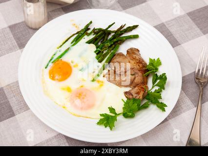 Fegato di coniglio arrosto con uova fritte e asparagi Foto Stock