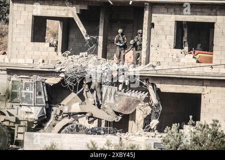 Jenin, Palestina. 13 giugno 2024. I soldati israeliani recuperano il corpo di un pistolero palestinese che si è barricato in una casa esplosa con missili a spalla nella città di Qabatiya vicino a Jenin in Cisgiordania. Il Ministero della salute palestinese ha detto che durante l'operazione militare, tre palestinesi sono stati uccisi e molti sono rimasti feriti. Dopo un raid da parte delle forze israeliane, l'assassinio di due palestinesi. (Foto di Nasser Ishtayeh/SOPA Images/Sipa USA) credito: SIPA USA/Alamy Live News Foto Stock