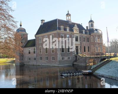 Castello storico con fossato e ponte, circondato da alberi e cielo azzurro, ruurlo, gheldria, paesi bassi Foto Stock