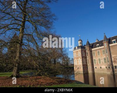 Un castello storico con un fossato, circondato da grandi alberi e un cielo blu, ruurlo, gheldria, paesi bassi Foto Stock