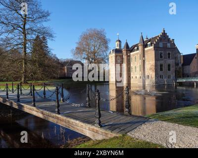 Castello storico con fossato e ponte, circondato da alberi e cielo azzurro, ruurlo, gheldria, paesi bassi Foto Stock