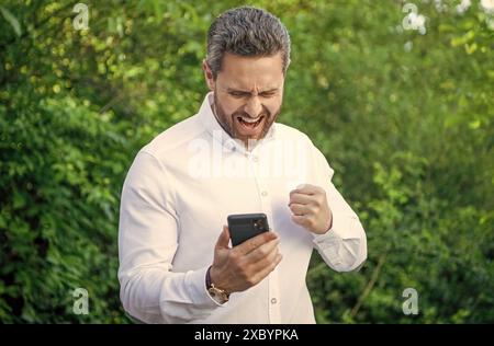 arrabbiato urlando un uomo d'affari di marketing con il telefono all'aperto. uomo d'affari di marketing Foto Stock