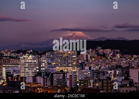 Resplandor de luz de la luna saliendo atrás del Volcán Cayambe al anochecer Foto Stock