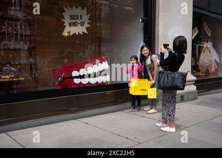 Passanti e amanti dello shopping interagiscono con una grande serie di denti a chiacchierare, una versione ridotta dell'originale di Eddy Goldfarb del 1949 chiamata "Yakity-Yak Talking Teeth", che sono presenti in una vetrina del grande magazzino Selfridges in Oxford Street, il 13 giugno 2024, a Londra, Inghilterra. Foto Stock