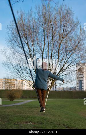 Giovane uomo in equilibrio sulla linea di lentezza. Foto Stock