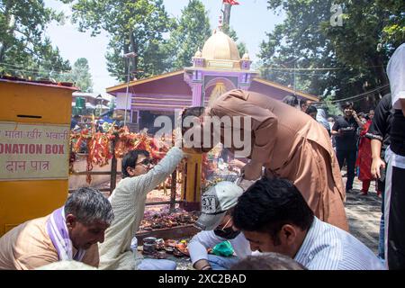 Ganderbal, Jammu e Kashmir, India. 14 giugno 2024. I devoti del Kashmiri Pandit eseguono rituali durante l'annuale festival indù al tempio Kheer Bhawani a Tullamulla, Ganderbal. Centinaia di devoti indù partecipano alle preghiere presso lo storico tempio Kheer Bhawani durante il festival annuale dedicato alla dea indù Durga. (Immagine di credito: © Adil Abass/ZUMA Press Wire) SOLO PER USO EDITORIALE! Non per USO commerciale! Foto Stock