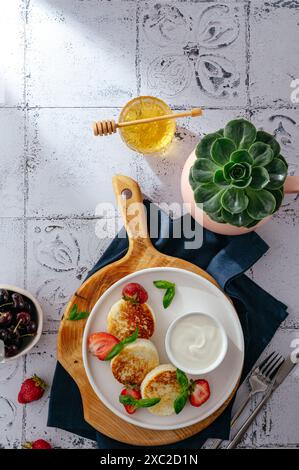 frittelle di formaggio cottage su un piatto con fragole e salsa. Foto Stock