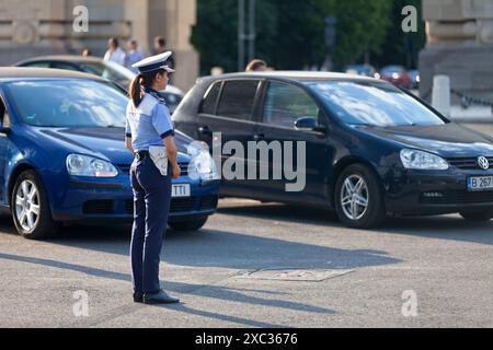 Bucarest, Romania - 24 giugno 2018: Poliziotta che fa il traffico ad Arcul de Triumf. Foto Stock