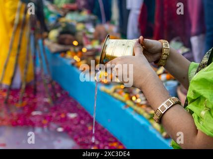 offerte di acqua santa da parte di devoti indiani che fanno rituali tradizionali al festival chhath al mattino Foto Stock