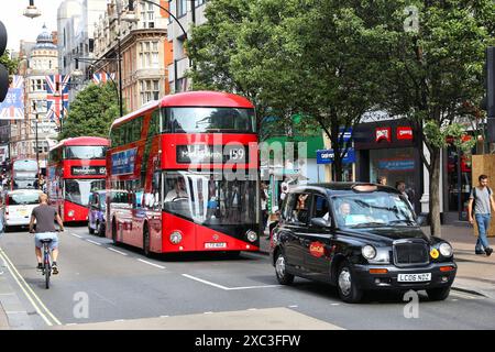 LONDRA, Regno Unito - 7 LUGLIO 2016: Le persone viaggiano sull'autobus New Routemaster a Oxford Street, Londra. L'autobus ibrido diesel-elettrico è una nuova e moderna versione di Iconic Foto Stock