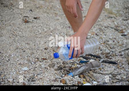 Il giovane volontario pulisce la spiaggia tropicale dall'inquinamento plastico. Primo piano. Foto Stock