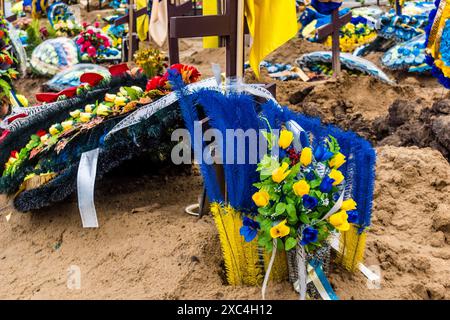Charkiv, Ucraina, 13 giugno 2024 Aleya Slavy, cimitero militare a sud di Charkiv. Le tombe dei soldati, eroi che hanno difeso l'Ucraina sono coperte Foto Stock