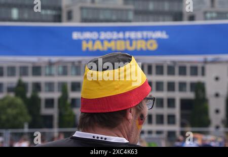 Amburgo, Germania. 14 giugno 2024. Calcio, UEFA Euro 2024, Germania - Scozia, turno preliminare, gruppo A, giorno partita 1. Un uomo che indossa un cappello da pescatore nero, rosso e oro si erge sul terreno del festival dei tifosi del Campionato europeo di Amburgo a Heiligengeistfeld prima dell'apertura. La partita di apertura del Campionato europeo tra Germania e Scozia sarà trasmessa in diretta la sera. Il Campionato europeo si svolge dal 14 giugno al 14 luglio. Crediti: Marcus Brandt/dpa/Alamy Live News Foto Stock