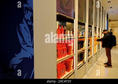 Un cliente sceglie lo Scottish whisky Scotch all'interno del negozio Johnnie Walker Princes Street nel West End di Edimburgo, Scozia, Regno Unito Foto Stock