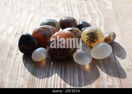 Cristalli curativi su un vecchio sfondo di legno. Agata del Botswana. Gemme multicolore, minerali. Agate di dimensioni diverse. Foto Stock