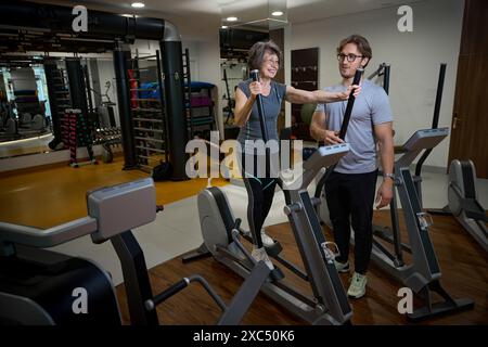 Signora anziana si sta allenando in una clinica di fitness Foto Stock