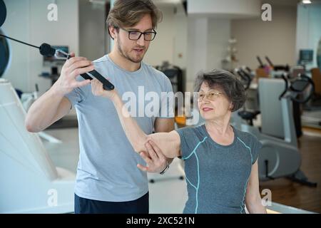 La pensionessa svolge esercizi per rafforzare i muscoli Foto Stock