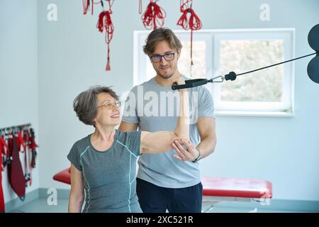 Una donna anziana esegue esercizi per rafforzare i muscoli del braccio e della schiena Foto Stock