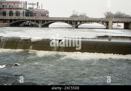 Aurora, Illinois, U.S.A., circa 1991. Fox River in inverno che scorre attraverso la città dall'Isola di Stolp e sopra la North Aurora Dam #2. Foto Stock