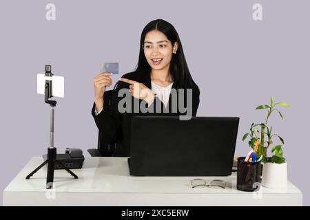 Una bellissima donna d'affari alla reception mostra un mockup di biglietti da visita Foto Stock