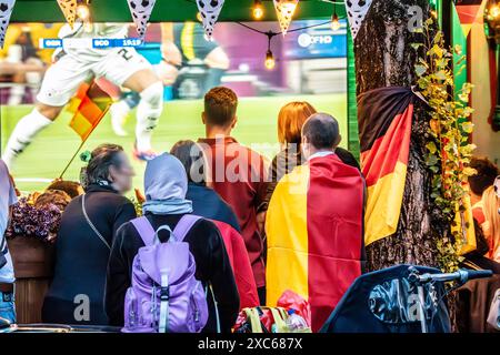 Public Viewing an der Leopoldstraße, Eröffnungsspiel Deutschland gegen Schottland, UEFA EURO 2024, München, 14. Juni 2024 Deutschland, München, 14. Juni 2024, deutsche Fußballfans beim Public Viewing an der Eröffnungsspiel beim Leopoldstraße Deutschland gegen Schottland, Endstand 5:1, hier in der ersten Halbzeit beim Stand von 2:0, deutsche Nationalspieler um Gündogan, Fußballfreunde mit Deutschlandfahnen bei der Live-Übertragung im Außenbereich einer Gastwirtschaft, die Fußball-Europameisterschaft dauert bis zum 14. Juli, Fußball, Sport, *** visione pubblica a Leopoldstraße, germe partita di apertura Foto Stock