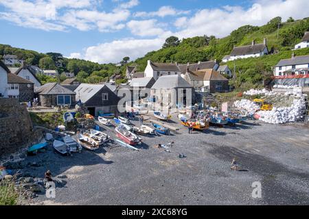Il porto di pescatori nel villaggio di Cadgwith, Cornovaglia, Inghilterra, con imbarcazioni ormeggiate sulla spiaggia di ciottoli. Foto Stock
