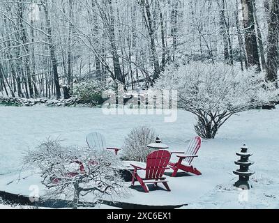 Patio innevato e paesaggio con sedie rosse Adirondack Foto Stock