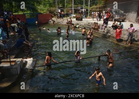 Gandarbal, India. 14 giugno 2024. I devoti indù fanno il bagno prima di pregare durante la festa annuale presso il tempio indù Kheer Bhawani a Tulla Mulla, a nord-est di Srinagar, Kashmir controllato dall'India, venerdì 14 giugno, 2024. centinaia di devoti indù hanno partecipato alle preghiere nello storico tempio Kheer Bhavani durante il festival annuale dedicato alla dea indù Durga. (Foto di Mubashir Hassan/Pacific Press) credito: Pacific Press Media Production Corp./Alamy Live News Foto Stock