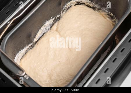 Macchina per il pane con impasto crudo sul tavolo, primo piano Foto Stock