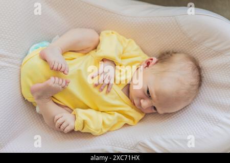 La pelle del neonato si sta staccando. La mamma utilizza prodotti per la pelle e massaggi per curare e lenire la delicata pelle del bambino, garantendo comfort e promozione Foto Stock