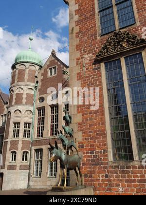 Statua in bronzo dei musicisti della città di Brema di fronte a uno storico edificio in mattoni alla luce del giorno, Brema, Germania Foto Stock