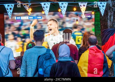 Public Viewing an der Leopoldstraße, Eröffnungsspiel Deutschland gegen Schottland, UEFA EURO 2024, München, 14. Juni 2024 Deutschland, München, 14. Juni 2024, deutsche Fußballfans beim Public Viewing an der Eröffnungsspiel beim Leopoldstraße Deutschland gegen Schottland, Endstand 5:1, hier in der ersten Halbzeit: Nationalspieler Florian Wirtz jubelt über sein 1:0 in der 10. Minuto, Fußballfreunde mit Deutschlandfahnen bei der Live-Übertragung im Außenbereich einer Gastwirtschaft, die Fußball-Europameisterschaft dauert bis zum 14. Juli, Fußball, Sport, *** visione pubblica a Leopoldstraße, openi Foto Stock