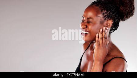 Dentista afroamericano focalizzato che fornisce il trattamento per una giovane donna con un mal di denti doloroso in ambiente Medical Office. Foto Stock