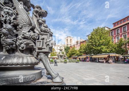 Dettagliate figure mitologiche su un palo in ferro battuto in Plaza de Bib Rambla con la cattedrale sullo sfondo a Granada, Spagna. Foto Stock