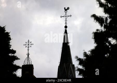 Ein Kreuz mit Wetterhahn steht auf dem Dach einer Kirche vor Wolkenhimmel Der Kirchenaustritt ist die vom Bürger auf eigenen Wunsch veranlasste Beendigung der staatlich registrierten Mitgliedschaft in einer Kirche. Themenbild, Symbolbild Frechen, 14.05.2024 NRW Deutschland *** Una croce con un rubinetto si erge sul tetto di una chiesa di fronte a un cielo nuvoloso che lascia la chiesa è la cessazione dell'appartenenza statale a una chiesa su richiesta dei cittadini immagine a tema, immagine simbolica Frechen, 14 05 2024 NRW Germania Copyright: xChristophxHardtx Foto Stock