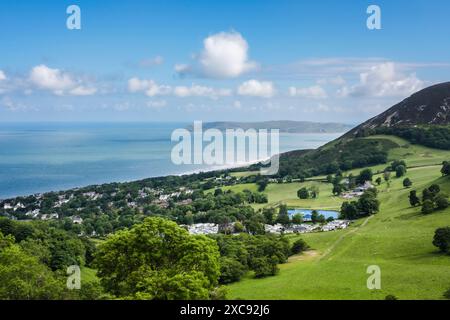 Vista alta del villaggio sotto Foel LU sulla costa panoramica con Great orme in lontananza. Penmaenmawr, Conwy, Galles del nord, Regno Unito, Gran Bretagna Foto Stock