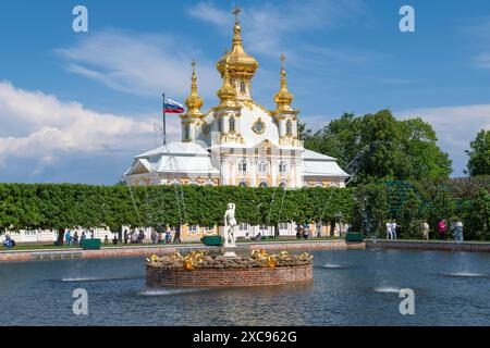 PETRODVORETS, RUSSIA - 4 GIUGNO 2024: Fontana e Chiesa di Pietro e Paolo del complesso del palazzo Peterhof in una giornata di sole Foto Stock