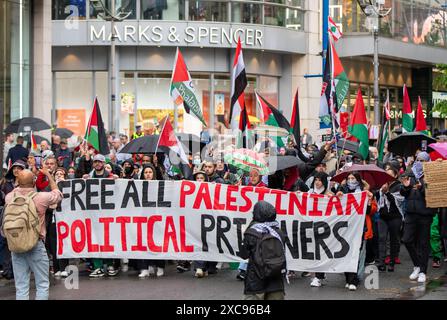 Manchester, Regno Unito. 15 giugno 2024. Palestina proteste di guerra a Gaza a Manchester nel Regno Unito durante le forti piogge. I manifestanti hanno marciato da Piazza San Pietro attraverso il centro della città. Gli striscioni includevano messaggi che chiedevano a Israele di liberare i prigionieri politici palestinesi e criticavano la Barclays Bank. Crediti: GaryRobertsphotography/Alamy Live News Foto Stock