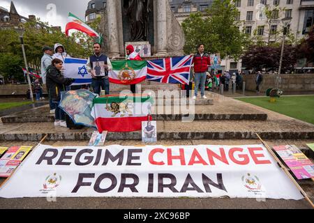 Manchester, Regno Unito. 15 giugno 2024. Il cambio di regime per i manifestanti iraniani protestano contro le proteste di guerra in Palestina a Gaza a Manchester nel Regno Unito durante le forti piogge. I manifestanti hanno marciato da Piazza San Pietro attraverso il centro della città. Gli striscioni includevano messaggi che chiedevano a Israele di liberare i prigionieri politici palestinesi e criticavano la Barclays Bank. Crediti: GaryRobertsphotography/Alamy Live News Foto Stock