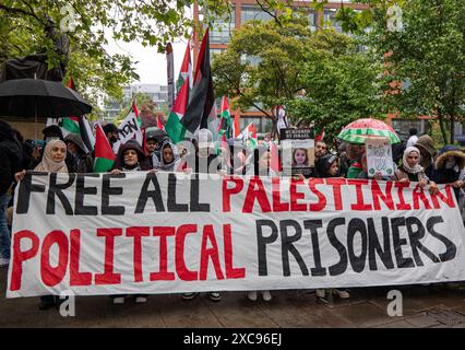 Manchester, Regno Unito. 15 giugno 2024. Striscione di prigionieri politici palestinesi liberi alle proteste di guerra in Palestina a Gaza a Manchester nel Regno Unito durante le forti piogge. I manifestanti hanno marciato da Piazza San Pietro attraverso il centro della città. Gli striscioni includevano messaggi che chiedevano a Israele di liberare i prigionieri politici palestinesi e criticavano la Barclays Bank. Crediti: GaryRobertsphotography/Alamy Live News Foto Stock