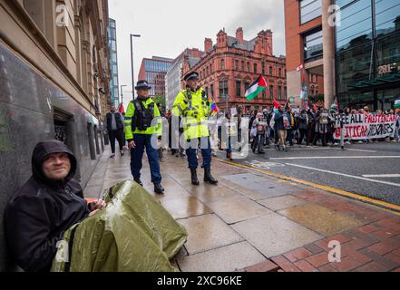 Manchester, Regno Unito. 15 giugno 2024. Un senzatetto attende l'arrivo delle proteste di guerra di Gaza in Palestina a Manchester nel Regno Unito durante le forti piogge. I manifestanti hanno marciato da Piazza San Pietro attraverso il centro della città. Gli striscioni includevano messaggi che chiedevano a Israele di liberare i prigionieri politici palestinesi e criticavano la Barclays Bank. Crediti: GaryRobertsphotography/Alamy Live News Foto Stock