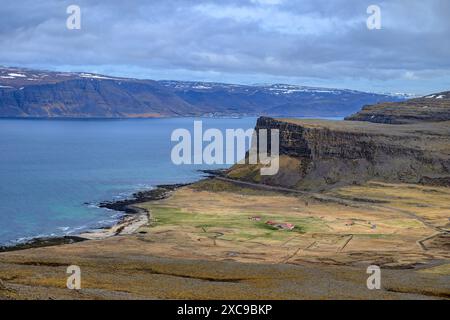 Il piccolo insediamento di Haenuvik (Patreksfjordur, Westfjords), Islanda con la città di Patreksfjordur sullo sfondo. Foto Stock