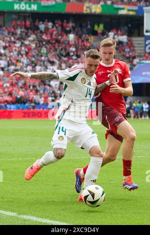 Colonia, Germania. 15 giugno 2024. L'Ungheria Bendeguz bolla (L) affronta con la Svizzera Michel Aebischer durante la partita UEFA Euro 2024 di gruppo A tra Ungheria e Svizzera a Colonia, in Germania, 15 giugno 2024. Crediti: Meng Dingbo/Xinhua/Alamy Live News Foto Stock