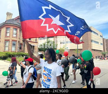 Racine, Wisconsin, Stati Uniti. 15 giugno 2024. La bandiera del primo giorno è portata da uno studente delle scuole superiori nella parata del primo giorno nel centro di Racine, Wisconsin, sabato 15 giugno 2024. (Credit Image: © Mark Hertzberg/ZUMA Press Wire) SOLO PER USO EDITORIALE! Non per USO commerciale! Foto Stock