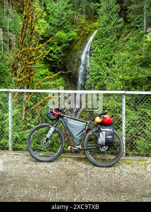 WA25371-00...WASHINGTON - bicicletta caricata per il trasporto delle biciclette parcheggiata su un albero lungo il Palouse-Cascades State Park Trail a Mine Creek. Foto Stock