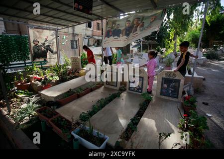 Nablus, Palestina. 15 giugno 2024. Bambini palestinesi visti accanto a tombe decorate nella città di Nablus, a nord della Cisgiordania, davanti a Eid al-Adha. Credito: SOPA Images Limited/Alamy Live News Foto Stock